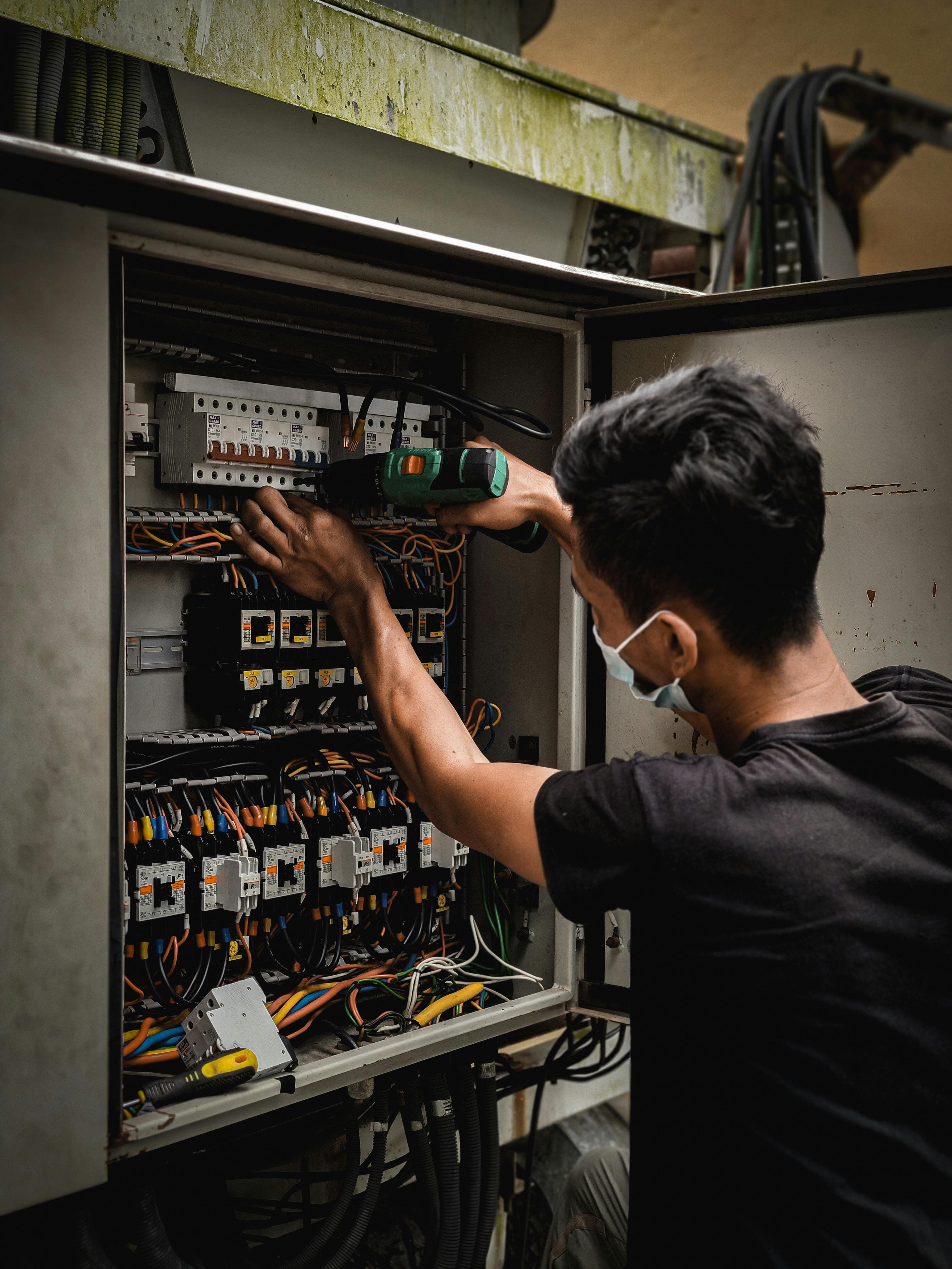 Electrician working inside an electrical panel